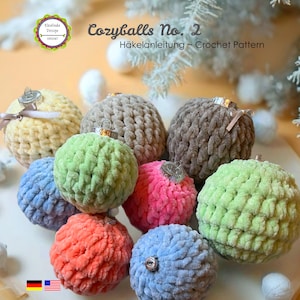 May include: A collection of round, textured crochet ornaments in various colors including yellow, green, blue, pink, and brown. Each sphere features a metallic cap with a small ribbon. The text reads Cozyballs No. 2 Häkelanleitung ~ Crochet Pattern.