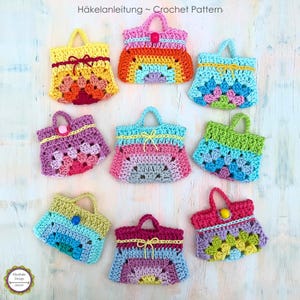 Può includere: Nove borse a mano in miniatura all'uncinetto in varie combinazioni di colori, tra cui giallo, rosa, blu, verde e arancione. Ogni borsa presenta un manico, un laccetto o una perlina decorativa e un motivo testurizzato. Il testo Häkelanleitung ~ Crochet Pattern è visibile.