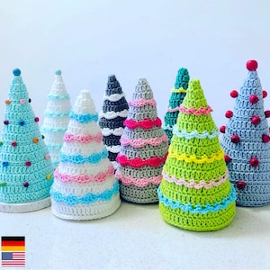Peut inclure: Une collection de neuf décorations de sapin de Noël en crochet de différentes couleurs, notamment bleu, vert, rose et gris. Chaque arbre est décoré de perles colorées et présente un design unique.