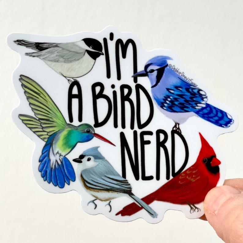 May include: A white sticker with the text "I'm a bird nerd" in black. The sticker features five colorful birds: a blue jay, a hummingbird, a cardinal, and two chickadees.