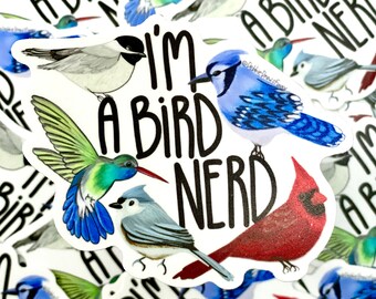 May include: A white sticker with the text "I'm a bird nerd" in black. The sticker features illustrations of five different birds: a blue jay, a hummingbird, a cardinal, a chickadee, and a black-capped chickadee.