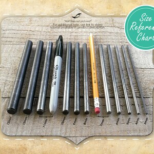 May include: A size reference chart with various metal rods ranging from 3mm to 13mm in diameter. A black Sharpie marker and a yellow pencil are included for size comparison. The chart is on a wooden background.