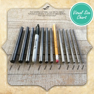 May include: Visual size chart showing 10 different sizes of metal rods, ranging from 3mm to 13mm in diameter. The rods are arranged in order of size, with the smallest rod on the right and the largest rod on the left. The chart also includes a pencil and a marker for scale.