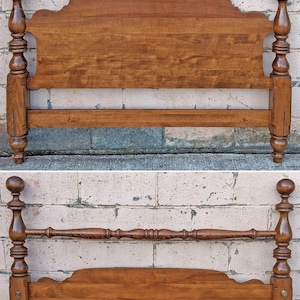 May include: A wooden bed frame set consisting of a headboard and a footboard. The headboard features a large, arched panel with turned posts and spherical finials. The footboard includes a lower arched panel, turned posts, and a horizontal rail.