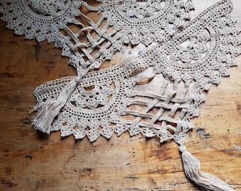 Peut inclure: Deux galons en dentelle crochet beige avec des glands. La dentelle a un design délicat et complexe avec un bord festonné.