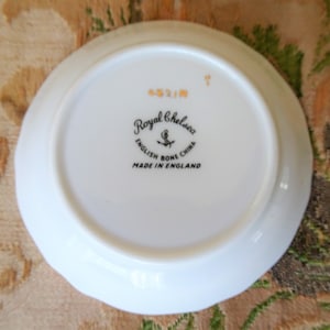 Puede incluir: Plato blanco con un sello negro y dorado Royal Chelsea English Bone China Made in England en la parte inferior.
