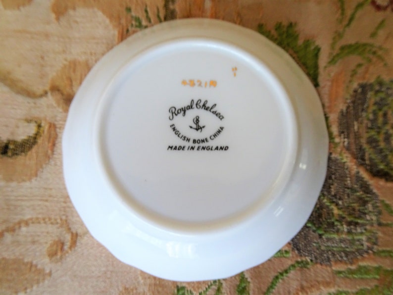 Puede incluir: Plato blanco con un sello negro y dorado Royal Chelsea English Bone China Made in England en la parte inferior.