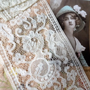 May include: White lace trim with a delicate floral pattern. The lace is soft and sheer, with a subtle sheen. It would be perfect for adding a touch of elegance to any project.