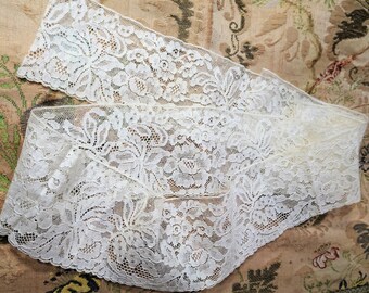 May include: White lace trim with a delicate floral pattern. The lace is soft and flowing, and would be perfect for adding a touch of elegance to any project.