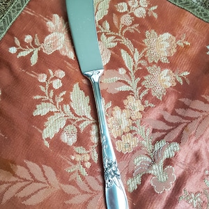 Precioso cuchillo de mantequilla vintage de plata con diseño de orquídea blanca, marca Community Silver Plate, Oneida. En buen estado, ideal para regalar. Repuesto.