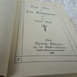 Pode incluir: Livro aberto com o t&iacute;tulo "Ruy Blas Les Burgraves" de Victor Hugo. A capa apresenta texto preto, o nome da editora, o endere&ccedil;o e o ano de 1930. As p&aacute;ginas s&atilde;o de cor creme.