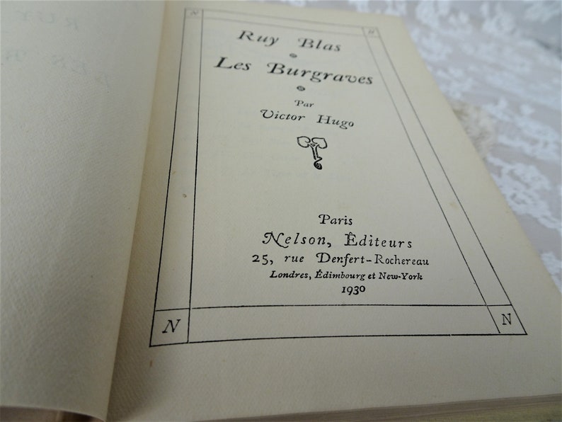 Pode incluir: Livro aberto com o t&iacute;tulo "Ruy Blas Les Burgraves" de Victor Hugo. A capa apresenta texto preto, o nome da editora, o endere&ccedil;o e o ano de 1930. As p&aacute;ginas s&atilde;o de cor creme.