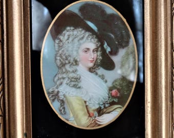May include: A framed portrait of a woman in a yellow dress and a large black hat with a white feather. The portrait is set against a blue and green background with a red rose.