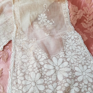 May include: Cream-colored lace scarf with a floral daisy pattern. The delicate fabric features an openwork design with scalloped edges. The scarf is made of a sheer, lightweight material, perfect for adding a touch of vintage elegance.