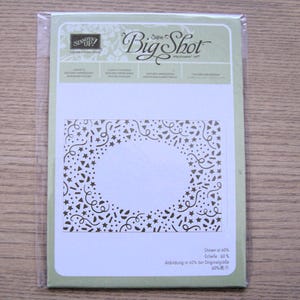 May include: A Stampin' Up! Big Shot die-cutting machine accessory. The die-cut design features a central circle surrounded by a pattern of stars, confetti, and swirls. The packaging is light green and white.