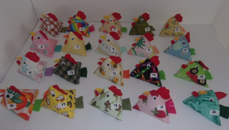 May include: Twenty handmade fabric chickens in various colors and patterns, numbered 1 through 20. Each chicken is a triangular shape with a red comb and beak.