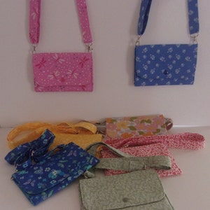 May include: A collection of nine small fabric purses with different patterns and colors. The purses have adjustable straps and are perfect for carrying small items like keys, phones, and wallets.