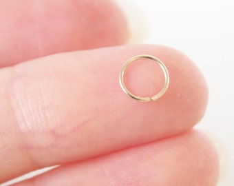 以下が含まれることがあります： 小さな金色のフープイヤリング。フープは細く、滑らかな仕上がりです。