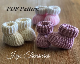 Könnte beinhalten: PDF-Muster für gehäkelte Babyschuhe in Weiß, Rosa und Lila. Die Schuhe haben eine gerippte Textur und einen umgeschlagenen Bund.