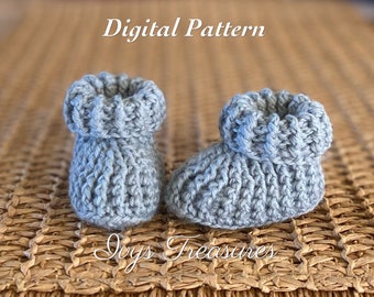 Könnte beinhalten: Ein Paar graue gehäkelte Babyschuhe mit gerippter Struktur. Die Schuhe haben einen umgeschlagenen Bund und liegen auf einer gewebten Oberfläche. Der Text "Digital Pattern" ist über den Schuhen sichtbar.