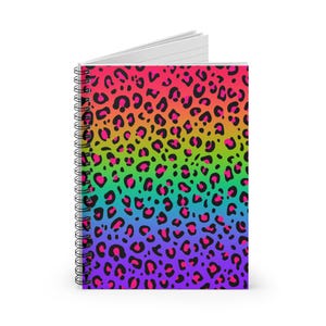 May include: A spiral bound notebook with a rainbow gradient leopard print cover. The print features black spots on a background that transitions from red to orange, yellow, green, blue, indigo, and violet.