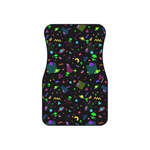 May include: Black car floor mat with a colorful pattern of aliens, planets, and geometric shapes in neon colors.