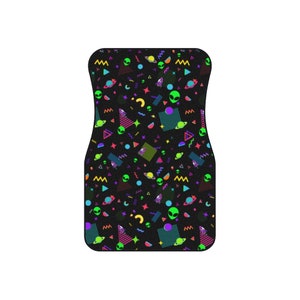 May include: A black car floor mat with a colorful geometric pattern featuring green aliens, planets, and stars. The pattern is reminiscent of 1980s and 1990s retro designs.