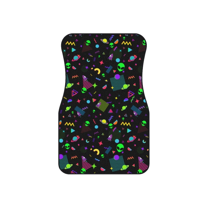 May include: A black car floor mat with a colorful geometric pattern featuring green aliens, planets, and stars. The pattern is reminiscent of 1980s and 1990s retro designs.
