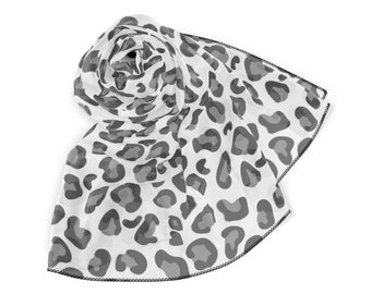 May include: A white scarf with a gray leopard print pattern. The scarf is folded and rolled up, with the edges sewn with a black thread.