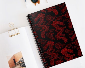 May include: A black spiral notebook with a red and white Chinese dragon pattern. The dragons are outlined in red and are surrounded by white clouds.