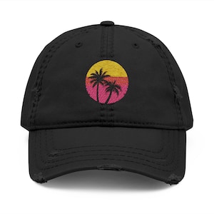 May include: Black distressed baseball cap with an embroidered design of two palm trees in a pink and yellow sunset.