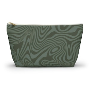 May include: A green and white zippered pouch with a swirling abstract pattern.