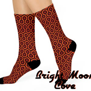 May include: A pair of orange and black socks with a geometric pattern. The socks are made of a soft, comfortable material and are perfect for everyday wear.