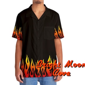 May include: A black short-sleeved button-down shirt with a flame pattern on the sleeves and bottom hem. The flames are yellow, orange, and red.