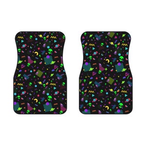 May include: A pair of black car floor mats with a colorful 80s retro pattern featuring green aliens, planets, and geometric shapes.
