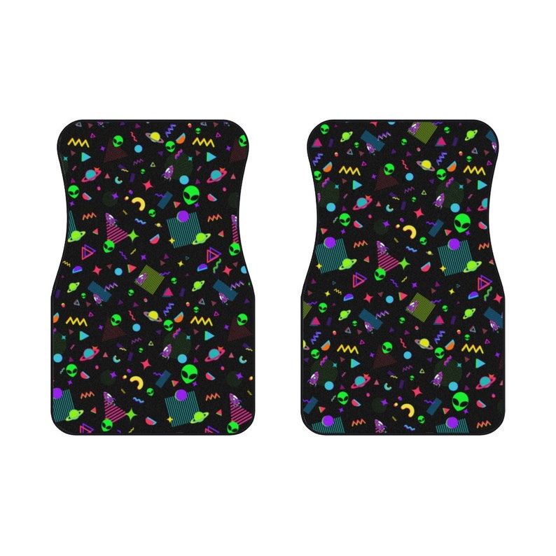 May include: A pair of black car floor mats with a colorful 80s retro pattern featuring green aliens, planets, and geometric shapes.