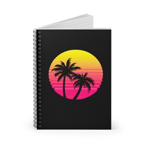 May include: A black spiral notebook with a pink and yellow sunset design featuring two palm trees in silhouette.