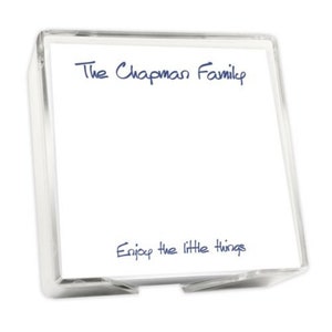 May include: A clear acrylic box filled with white note paper. The top of the paper has the text "The Chapman Family" in blue cursive writing. The bottom of the paper has the text "Enjoy the little things" in blue cursive writing.