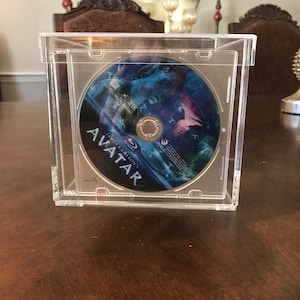 May include: A clear plastic case with a blue and purple DVD inside. The DVD is labeled "James Cameron's Avatar".