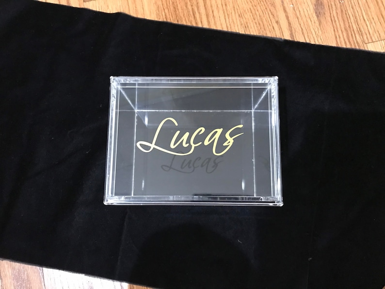 May include: A clear acrylic box with a gold inscription that reads "Lucas".