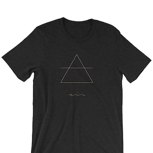 May include: A dark heather grey t-shirt with a gold triangle and line graphic and the word "air" written underneath.