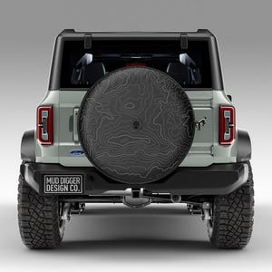 Custom Ford Bronco tire cover with backup camera port, designed for 2021-2025 models, weatherproof and UV-resistant. Perfect accessory for Ford Bronco owners, available in multiple colors and designs