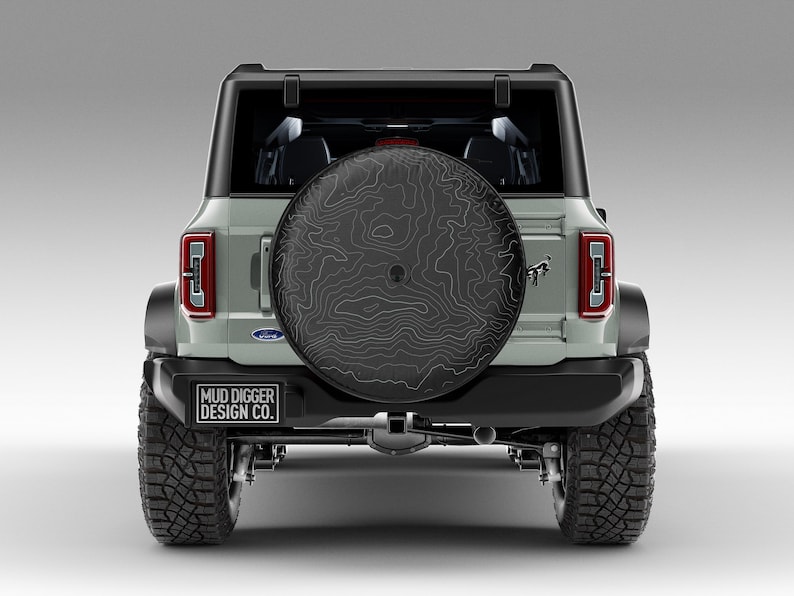 Custom Ford Bronco tire cover with backup camera port, designed for 2021-2025 models, weatherproof and UV-resistant. Perfect accessory for Ford Bronco owners, available in multiple colors and designs
