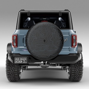 Custom Ford Bronco tire cover with backup camera port, designed for 2021-2025 models, weatherproof and UV-resistant. Perfect accessory for Ford Bronco owners, available in multiple colors and designs