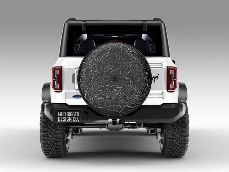 Custom Ford Bronco tire cover with backup camera port, designed for 2021-2025 models, weatherproof and UV-resistant. Perfect accessory for Ford Bronco owners, available in multiple colors and designs
