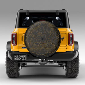 Custom Ford Bronco tire cover with backup camera port, designed for 2021-2025 models, weatherproof and UV-resistant. Perfect accessory for Ford Bronco owners, available in multiple colors and designs