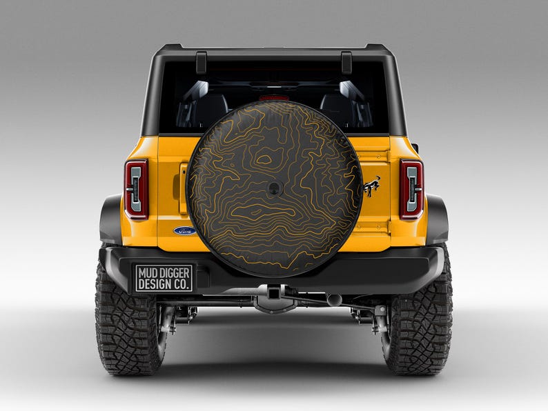 Custom Ford Bronco tire cover with backup camera port, designed for 2021-2025 models, weatherproof and UV-resistant. Perfect accessory for Ford Bronco owners, available in multiple colors and designs
