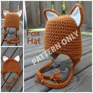 May include: A crocheted fox hat with a brown body and white ears. The hat has a long tail that ties under the chin. The hat is labeled "Fox Hat PATTERN ONLY".