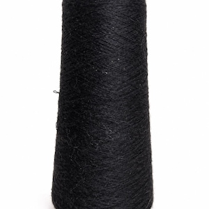 May include: A black yarn cone is displayed against a white backdrop. The yarn is tightly wound, creating a textured surface. The cone shape tapers from a wider base to a narrower top. This yarn is suitable for knitting and crochet projects.
