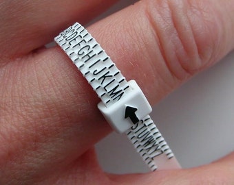 May include: White plastic ring sizer with black lettering. The sizer is marked with letters from A to Y.